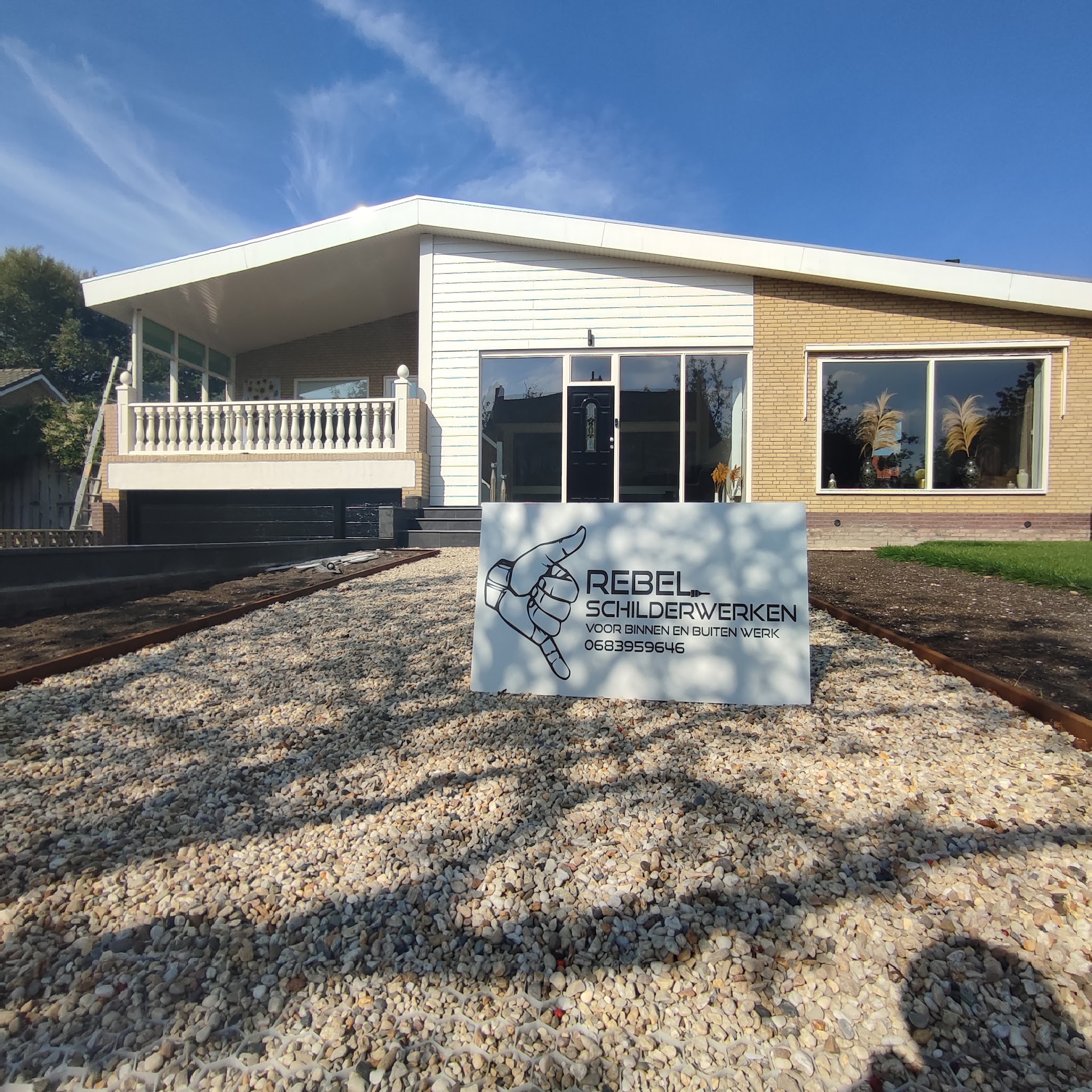 Pas geschilderde bungalow met het bord van Rebel Schilderwerken in de voortuin