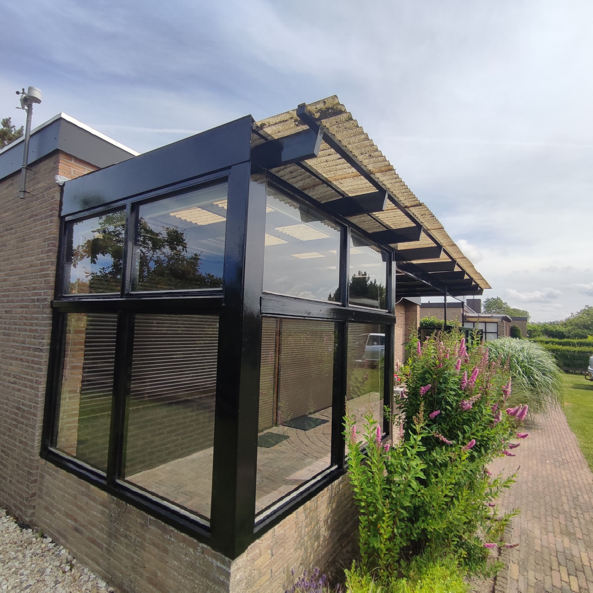 Aanbouw met glazen pui, kozijnen zwart gelakt