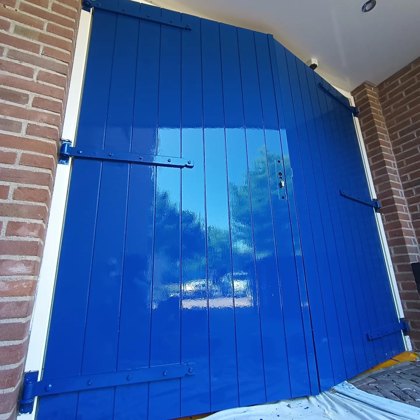 Dubbele houten deuren in felblauwe hoogglanslak