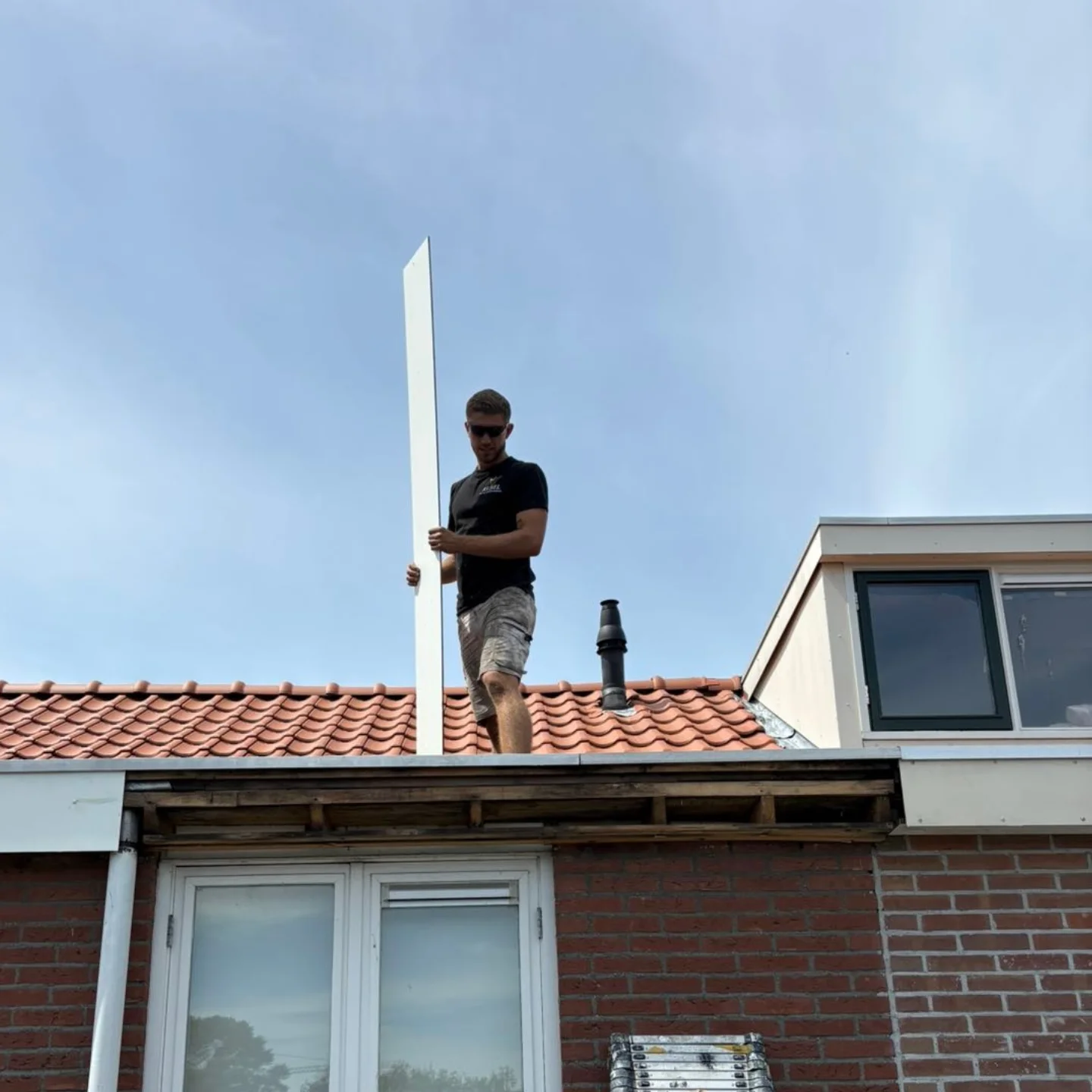 Rick op het dak bij het plaatsen van witte HPL boeidelen